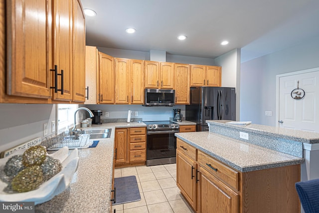 kitchen featuring light stone counters, sink, light tile patterned floors, and stainless steel appliances