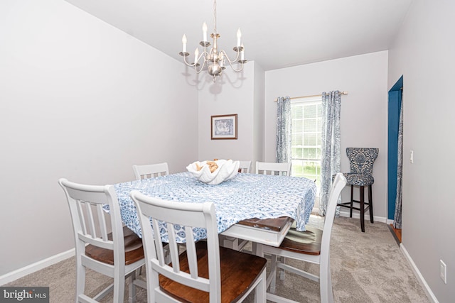 carpeted dining room featuring a chandelier