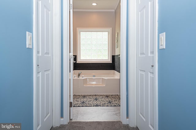 bathroom featuring a bathtub and crown molding