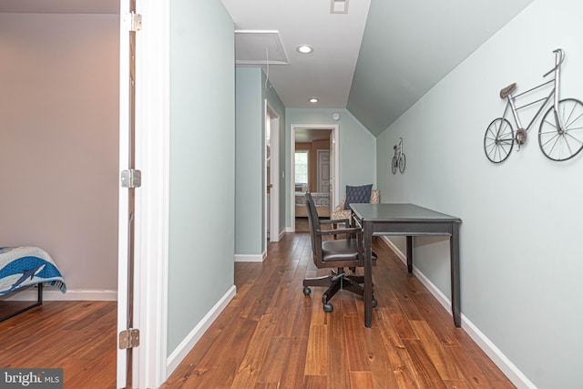 home office with vaulted ceiling and dark wood-type flooring