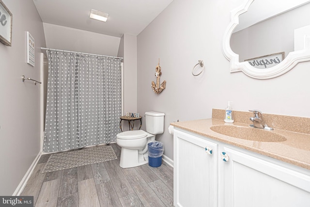 bathroom featuring hardwood / wood-style floors, vanity, toilet, and walk in shower