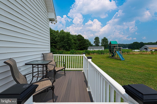 wooden deck featuring a yard and a playground