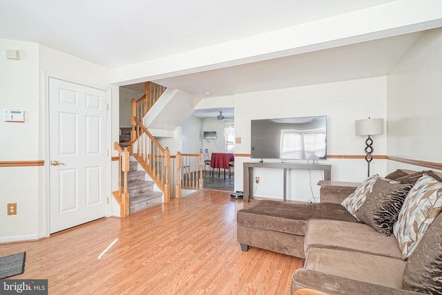 living room with beamed ceiling, ceiling fan, and light wood-type flooring