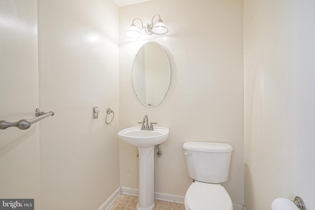 bathroom featuring tile patterned flooring, toilet, and sink