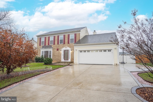 colonial home with a garage and a front lawn