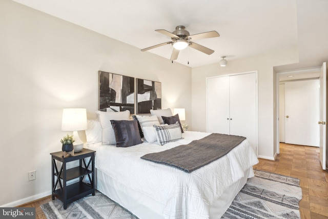 bedroom featuring parquet flooring, a closet, and ceiling fan