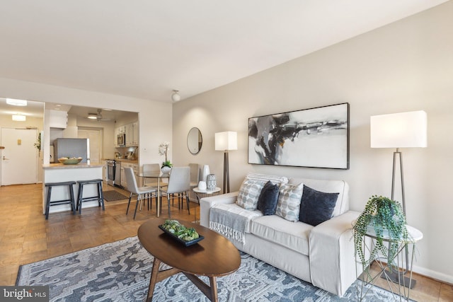 living room featuring ceiling fan and parquet floors