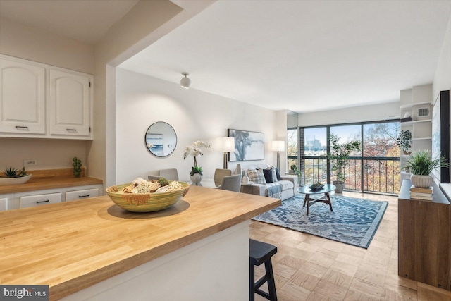 kitchen with white cabinets, a breakfast bar area, and butcher block counters