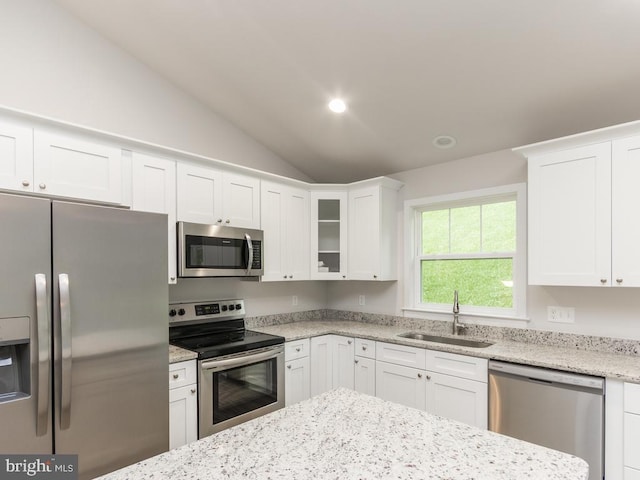 kitchen with sink, white cabinets, lofted ceiling, and appliances with stainless steel finishes