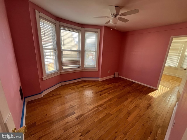 unfurnished room with hardwood / wood-style flooring and ceiling fan