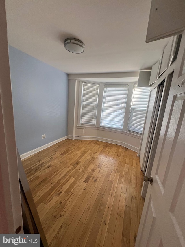 unfurnished room with light wood-type flooring