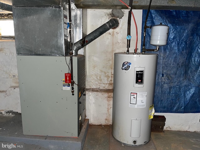 utility room featuring heating unit and electric water heater