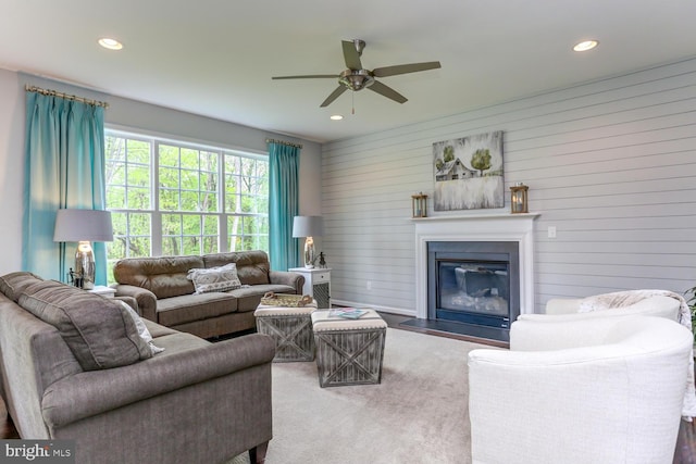 living room featuring ceiling fan and wood walls