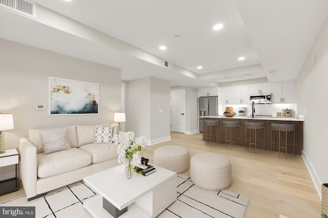 living room with sink and light hardwood / wood-style flooring