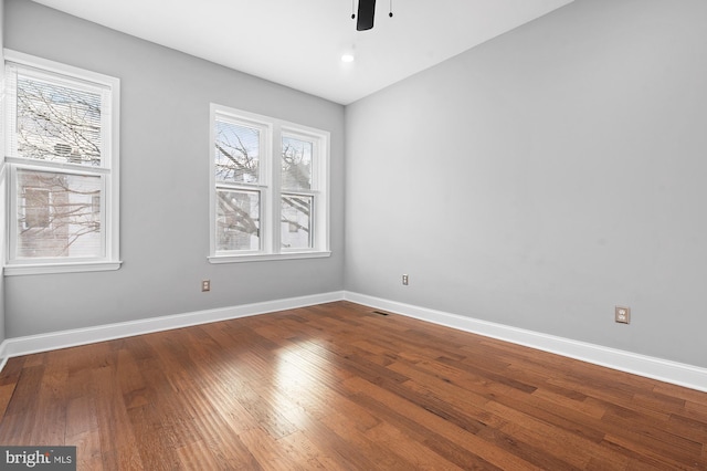 spare room featuring wood-type flooring, ceiling fan, and a healthy amount of sunlight