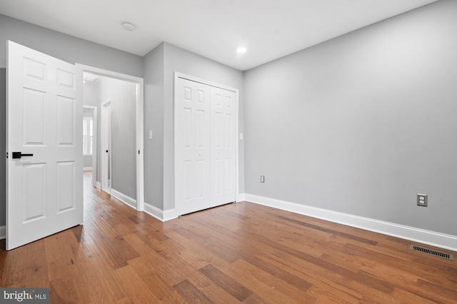 unfurnished bedroom featuring hardwood / wood-style flooring and a closet