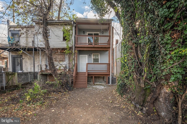 rear view of property with cooling unit and a balcony