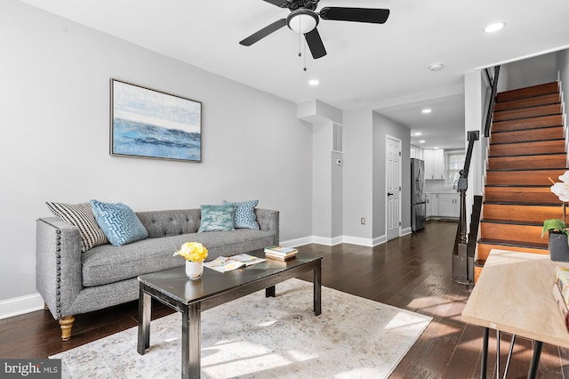 living room with ceiling fan and dark hardwood / wood-style flooring