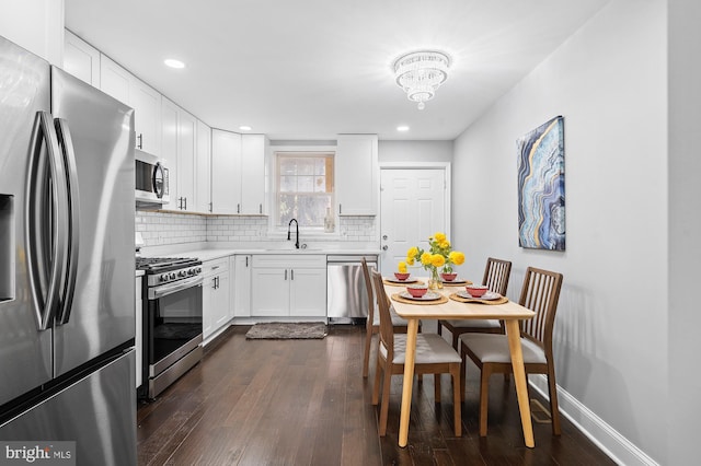 kitchen featuring backsplash, stainless steel appliances, sink, white cabinets, and dark hardwood / wood-style floors