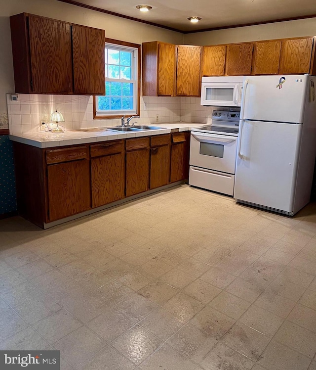 kitchen with white appliances, backsplash, and sink