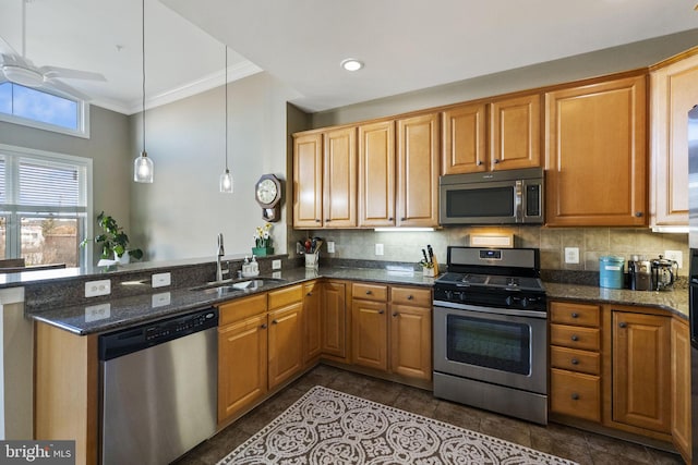 kitchen featuring ceiling fan, sink, dark stone countertops, decorative light fixtures, and appliances with stainless steel finishes