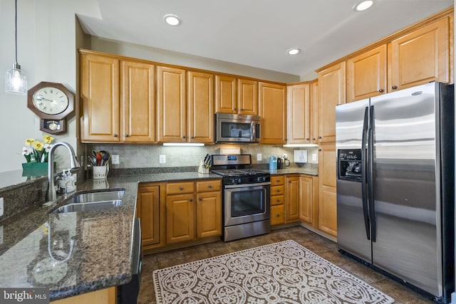 kitchen with kitchen peninsula, stainless steel appliances, sink, dark stone countertops, and hanging light fixtures