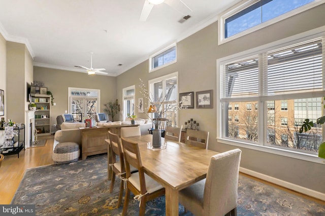 dining area with french doors, hardwood / wood-style flooring, ceiling fan, and crown molding