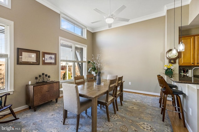 dining space with ceiling fan, dark hardwood / wood-style flooring, and ornamental molding