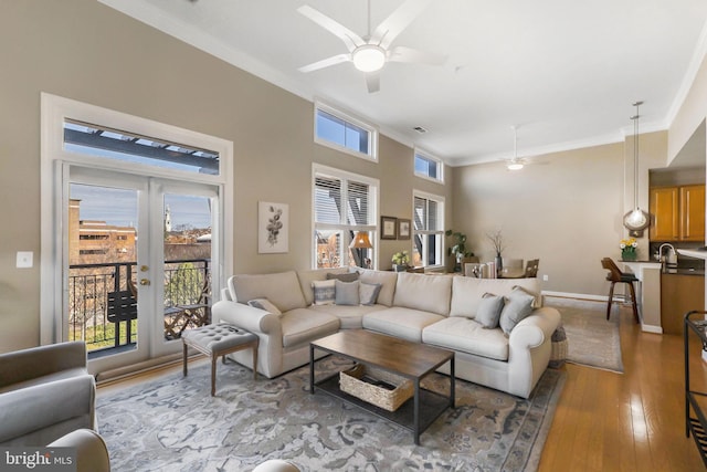 living room with hardwood / wood-style flooring, ceiling fan, crown molding, and french doors