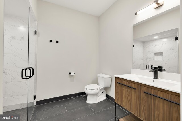 bathroom with tile patterned floors, vanity, toilet, and a shower with door