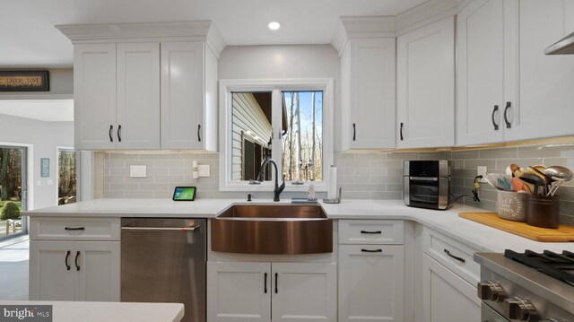 kitchen featuring sink, white cabinetry, stainless steel appliances, and tasteful backsplash