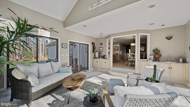 living room with lofted ceiling and light tile patterned floors