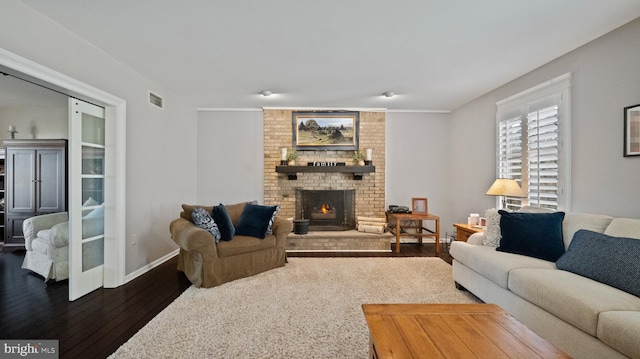 living room with dark hardwood / wood-style floors and a brick fireplace