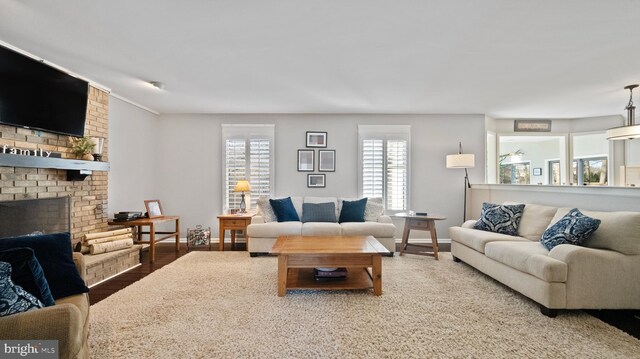 living room with wood-type flooring and a brick fireplace