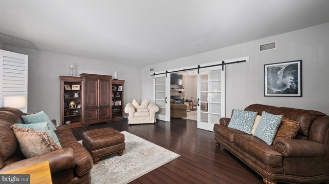 living room featuring dark hardwood / wood-style floors and a barn door