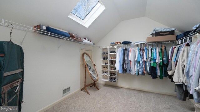 walk in closet with vaulted ceiling with skylight and carpet floors