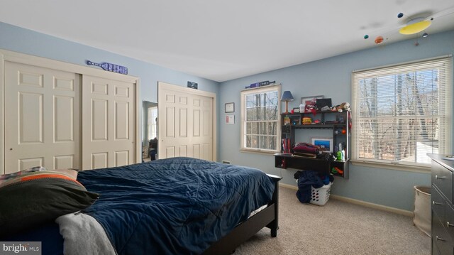 carpeted bedroom featuring two closets