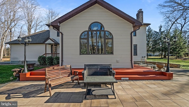 rear view of property with a patio and an outdoor hangout area