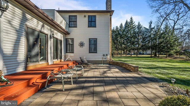 rear view of house with a lawn and a patio