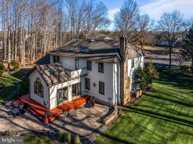 rear view of property featuring a patio and a lawn