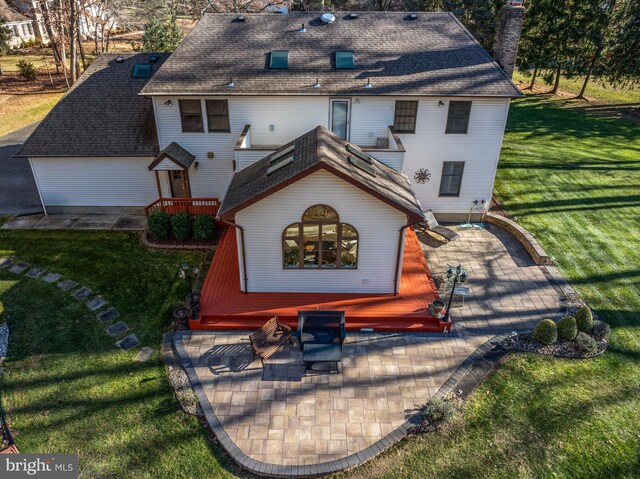 back of house with a patio and a lawn