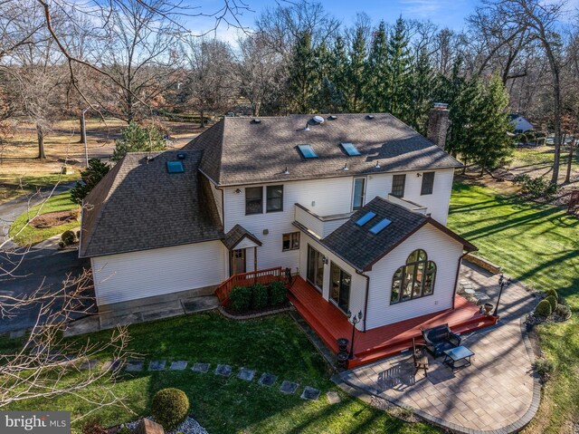 back of house featuring a lawn and a patio area