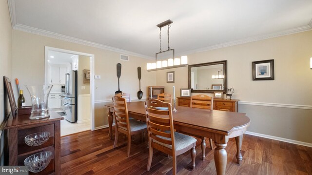 dining area featuring dark hardwood / wood-style floors and crown molding