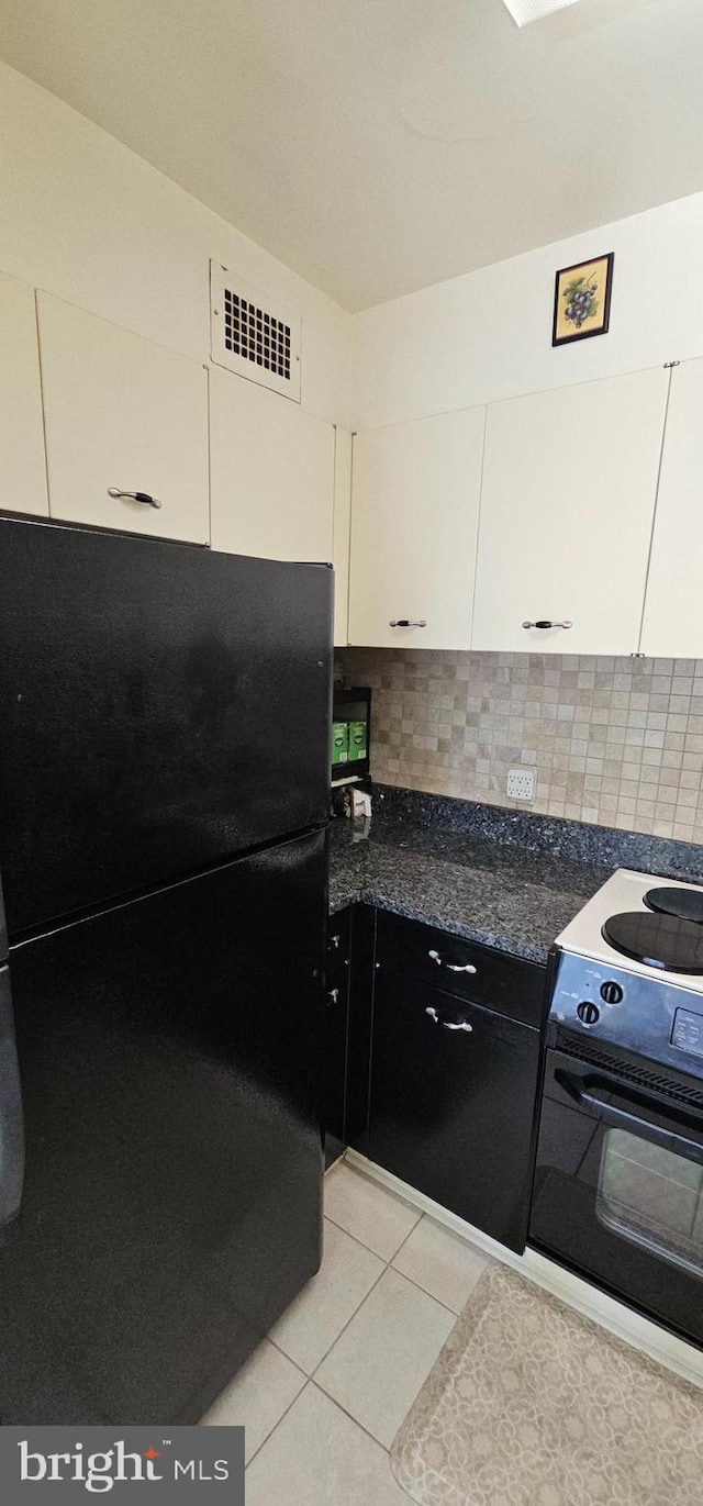 kitchen featuring light tile patterned flooring, decorative backsplash, white cabinets, and black appliances
