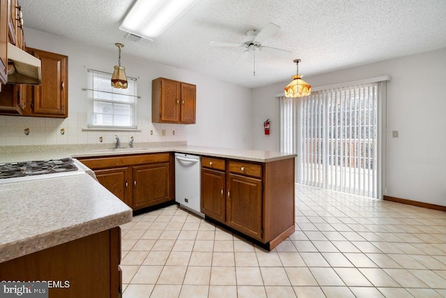 kitchen featuring sink, kitchen peninsula, white appliances, decorative light fixtures, and decorative backsplash