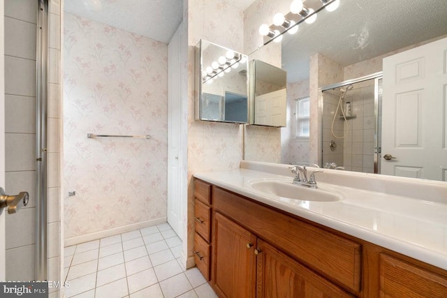 bathroom with tile patterned floors, a shower with door, vanity, and a textured ceiling