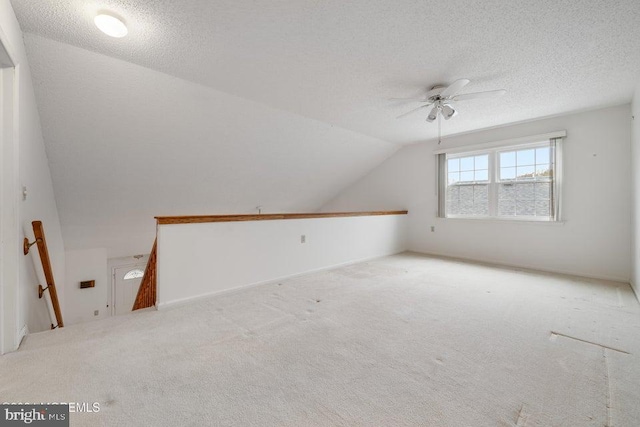 bonus room with ceiling fan, light colored carpet, lofted ceiling, and a textured ceiling