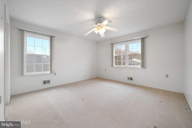 unfurnished room featuring a textured ceiling and a healthy amount of sunlight