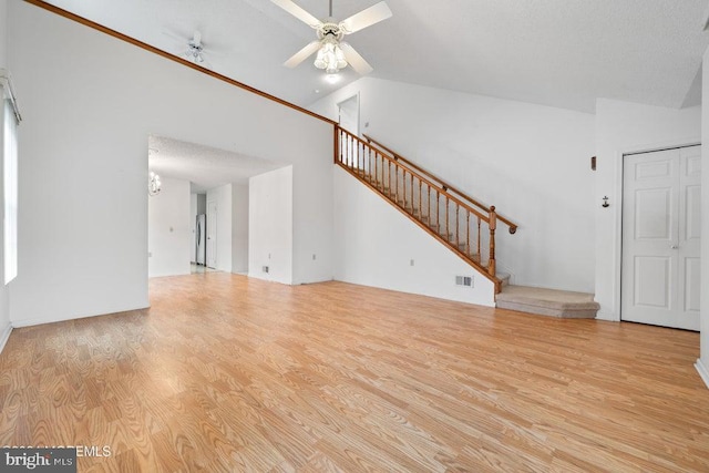 unfurnished living room with a textured ceiling, high vaulted ceiling, light hardwood / wood-style flooring, and ceiling fan