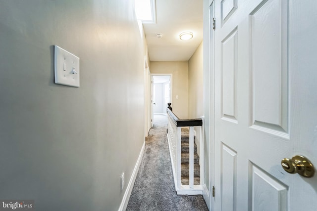 hall with dark colored carpet